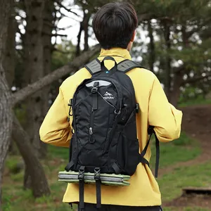 Detailansicht eines schwarzen Wanderrucksacks mit befestigter grüner Isomatte im Wald
