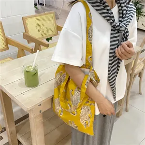 Λεπτομέρεια lifestyle μιας κίτρινης τσάντας tote μεγάλης χωρητικότητας με σχέδια τίγρης
