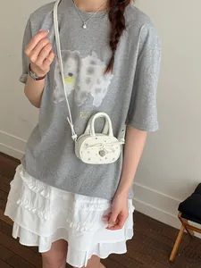 Small white floral bowling bag with bow and heart charm worn crossbody