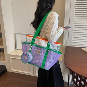 Model carrying large purple mesh tote bag with green straps and matching pouch