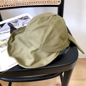 Vista detallada de un sombrero de sol para mujer verde oliva con lazo en una silla