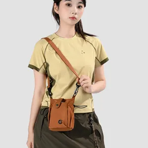 Vue détaillée d'un mini sac à bandoulière marron pour téléphone porté par un mannequin