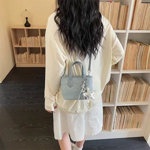 Rear view of a model carrying a small blue rhinestone crossbody bag with a star charm