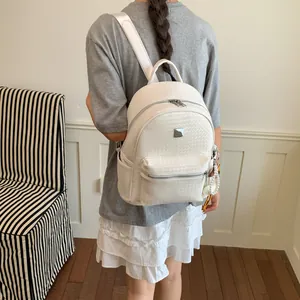 Vista dettagliata di uno zaino vintage bianco intrecciato indossato da una modella