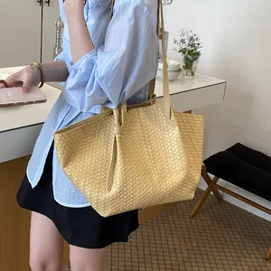 Elegant cream woven tote bag styled on shoulder with a minimalist aesthetic feel.