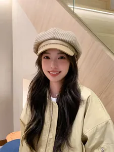 Close-up of model wearing a stylish beige striped newsboy cap for autumn fashion