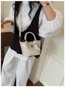Sac seau élégant en similicuir beige avec charm chien dans un décor lifestyle