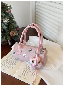 Macro view of a stylish pink barrel handbag with cartoon cat prints and a heart charm