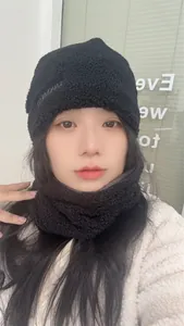 Détail d'un mannequin asiatique portant un bonnet sherpa noir et son cache-col