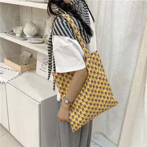 Φωτογραφία lifestyle μεγάλης κίτρινης τσάντας με φλοράλ σχέδιο για το καλοκαίρι