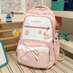 Detail view of a cute pink and white backpack with star patterns and bow decoration.