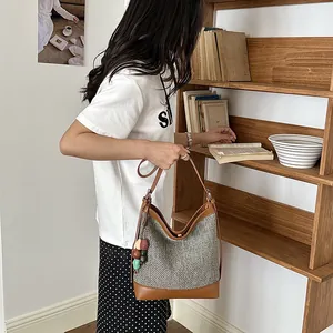 Lifestyle shot of a woven bucket bag with leather trim and colorful bead charms.