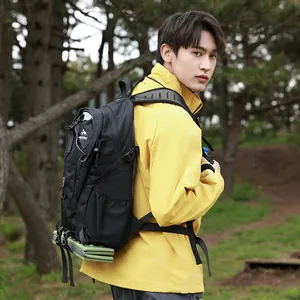 Ein junges männliches Modell trägt einen schwarzen Wanderrucksack in einem Wald