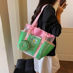 Detail view of a large capacity green and pink mesh tote bag for stylish women commuting