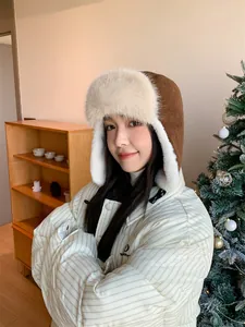 Close-up of a women's warm winter trapper hat with fluffy plush fur trim and ear flaps