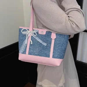 Sac cabas décontracté rose et bleu denim avec nœud en dentelle et breloque perle porté à l'épaule