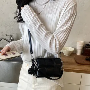 Woman wearing black woven padded underarm bag in a minimalist lifestyle setting