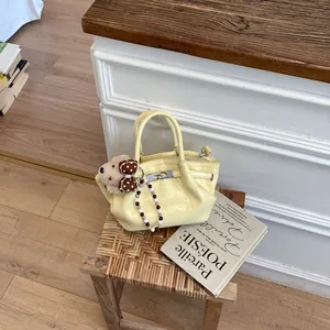 Elegante piccola borsa a secchiello gialla con ciondolo a orsetto e cinturino di perline