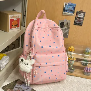 Close-up of pink student backpack showing star pattern and a cute plush bear charm