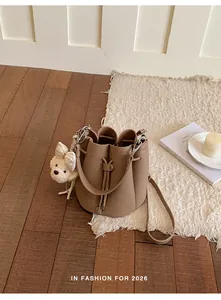 Detailed view of the 2026 trendy high-end bucket bag with a cute teddy bear charm
