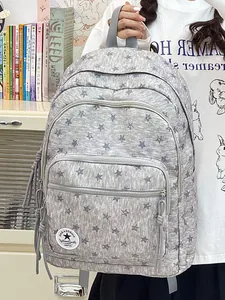 Detailed view of a grey star pattern backpack featuring a front pocket and zip tassels