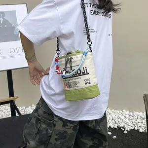 Detaillierte Makroansicht der lässigen grünen Canvas-Eimertasche mit bunten Seilriemen