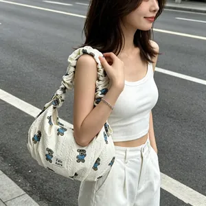 Exquisite women's dumpling shoulder bag with cute bear pattern in urban setting