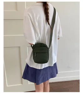 Back view of woman wearing a stylish dark green minimalist crossbody square bag