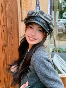 Fashionable woman wearing a vintage plaid newsboy cap with a black leather brim.