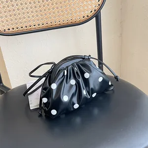 Macro detail of the stylish black and white polka dot crossbody handbag texture