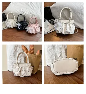 Detailed views of fresh polka dot pleated bucket bags with ribbon charms and handles
