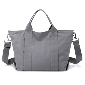 Vista dettagliata della borsa tote grigia grande con tracolla regolabile e trama in nylon.