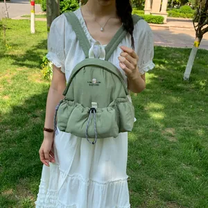 Primer plano de una mochila informal verde usada por una modelo en un parque natural