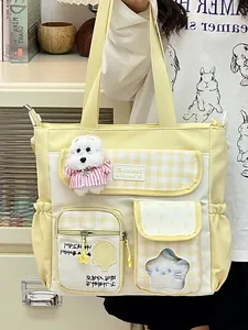 Süße gelbe Segeltuch-Tragetasche mit mehreren Taschen und einem Plüschanhänger.