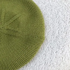 Close-up detail showing the soft green knitted wool texture of this winter beret hat