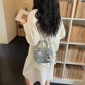 Detailed view of a trendy blue denim bucket bag with silver stars and adjustable strap