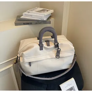 Gros plan d'un sac de voyage crème et gris avec fermeture éclair extensible et logo ZSSJ