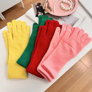 Close-up of colorful knitted gloves with touchscreen finger openings in four colors