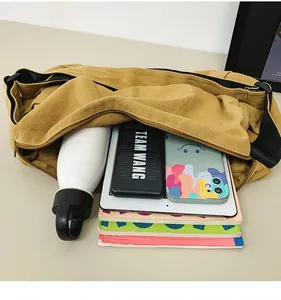 Detailed interior view of a large mustard yellow canvas messenger bag showing high capacity