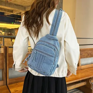 Back view of a stylish blue denim backpack worn by a model in a casual indoor setting