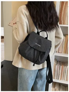 Back view of a trendy checkered backpack for women in a stylish indoor setting.