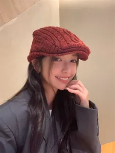 Detailed view of an elegant wine red cable knitted wool beret hat for winter warmth
