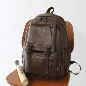 Sac à dos vintage en cuir marron sur une chaise en bois avec une batte de baseball