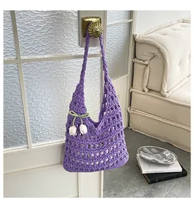 Detalle de estilo de un bolso tote de ganchillo morado con un lindo colgante de tulipán