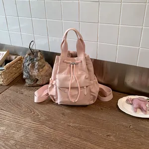 Primer plano detallado de una mochila rosa con cordón sobre una superficie de madera rústica