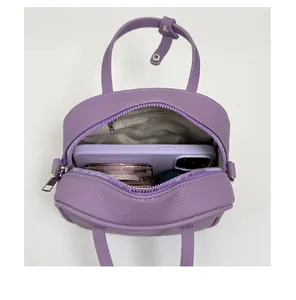 Detail der violetten Umhängetasche mit Platz für Smartphone und Make-up-Produkte
