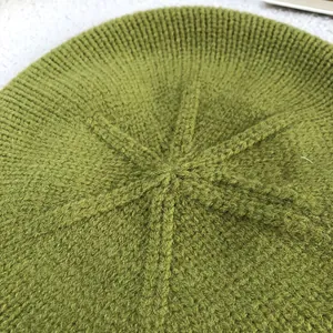 Macro detail of the top radiating knit pattern on a green wool beret