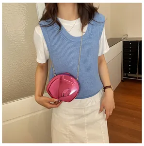 Dettaglio di una borsa da sera rosa a forma di conchiglia con finitura a specchio e catena