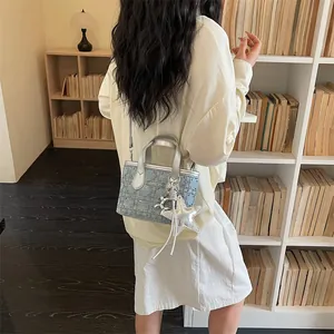 Lifestyle shot of a stylish silver and denim crossbody bag for women in a library