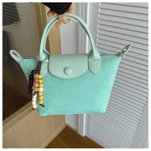 Vue détaillée d'un sac à main en daim vert menthe orné d'un accessoire en perles de bois colorées